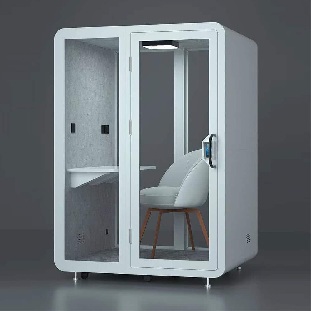 A modern, soundproof phone booth with glass doors, a white interior, a built in desk, and a cushioned chair inside.